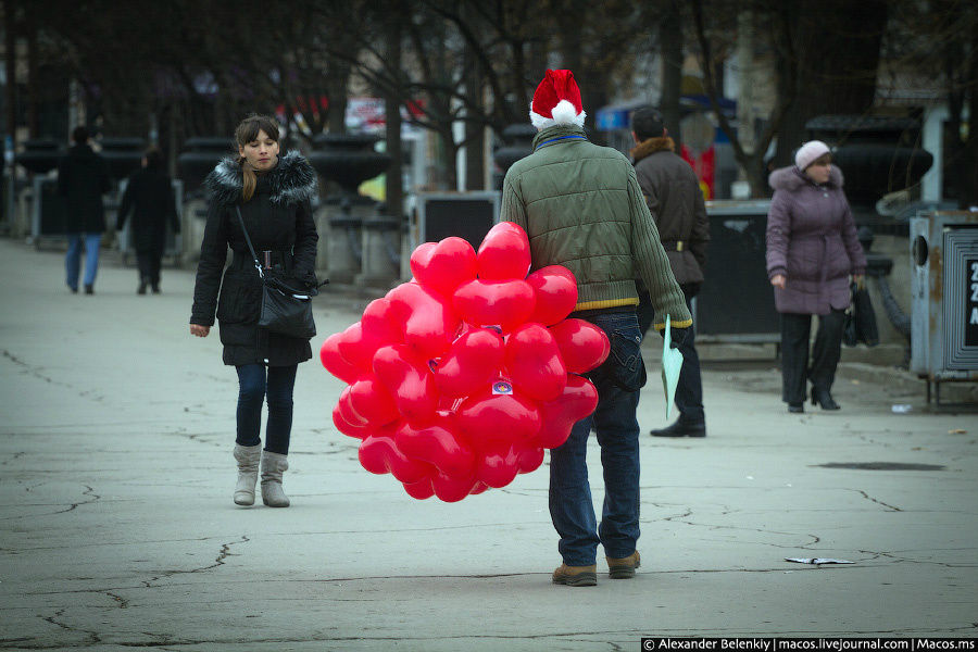 Молодые люди в шапках Санта-Клауса то ли дарили, то ли продавали девушкам воздушные шарики в виде сердечек. Кишинёв, Молдова