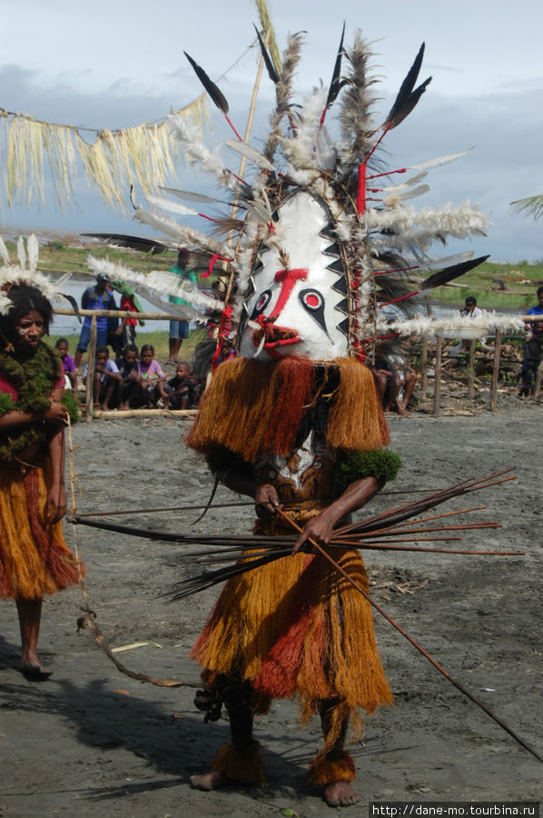 Одна маска с копьем, сзади — девушка держит на привязи маску Провинция Галф, Папуа-Новая Гвинея
