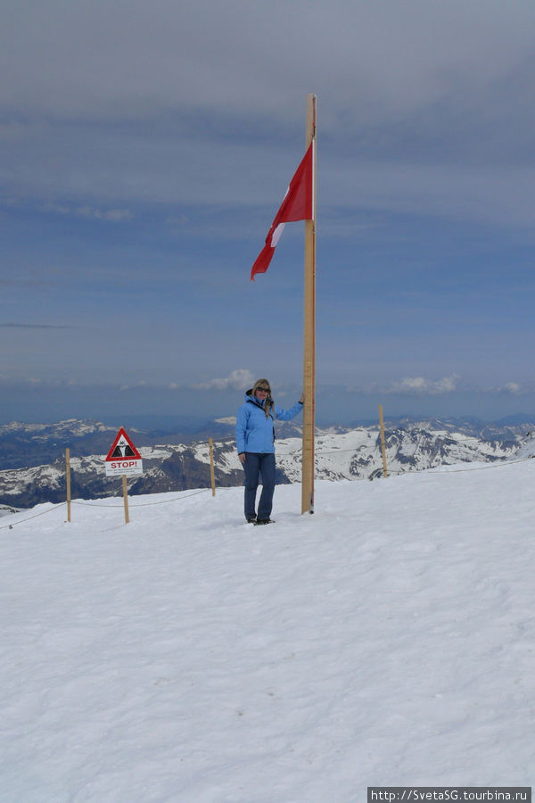 И я под Швейцарским флагом на крыше Европы. Здесь высота чуть поменьше, чем на Матерхорне, ноги слушаются, дышать нормально.
 И действительно непередаваемое ощущение, что весь мир лежит у твоих ног!  Жаль, что фото ощущения не передает. Юнгфрауйох (хребет 3471м), Швейцария