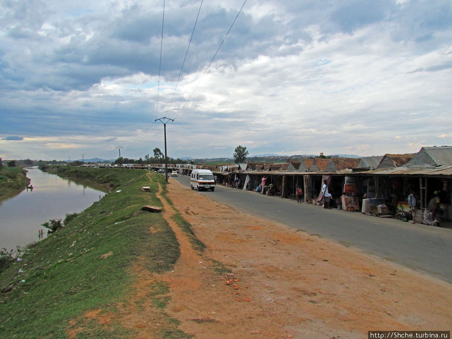 Рынок расположился справа, от дороги, а слева течет река Ikora Антананариву, Мадагаскар