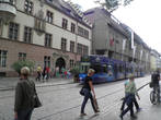Пройдя несколькими очаровательными переулками, мы вышли на Кайзер-Йозеф-Штрассе. Улица шумит: звенят трамваи, гул многоязычных групп туристов, по обе стороны множество магазинов.