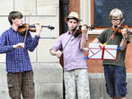 Трио молодых скрипачей исполняло что-то классическое без особого энтузиазма