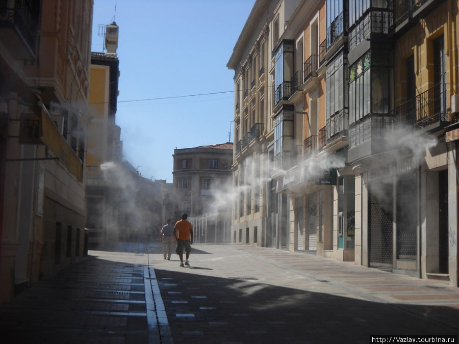 Парадный вид улицы. По бокам не дым — это территорию опрыскивают водой, чтобы гуляющих не так донимала жара Гвадалахара, Испания