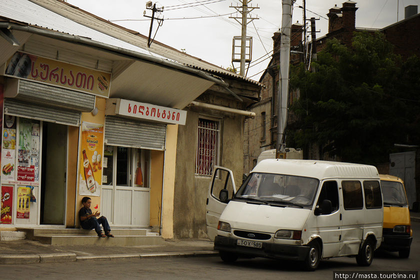 Мальчик играет у входа в магазин. Тбилиси, Грузия