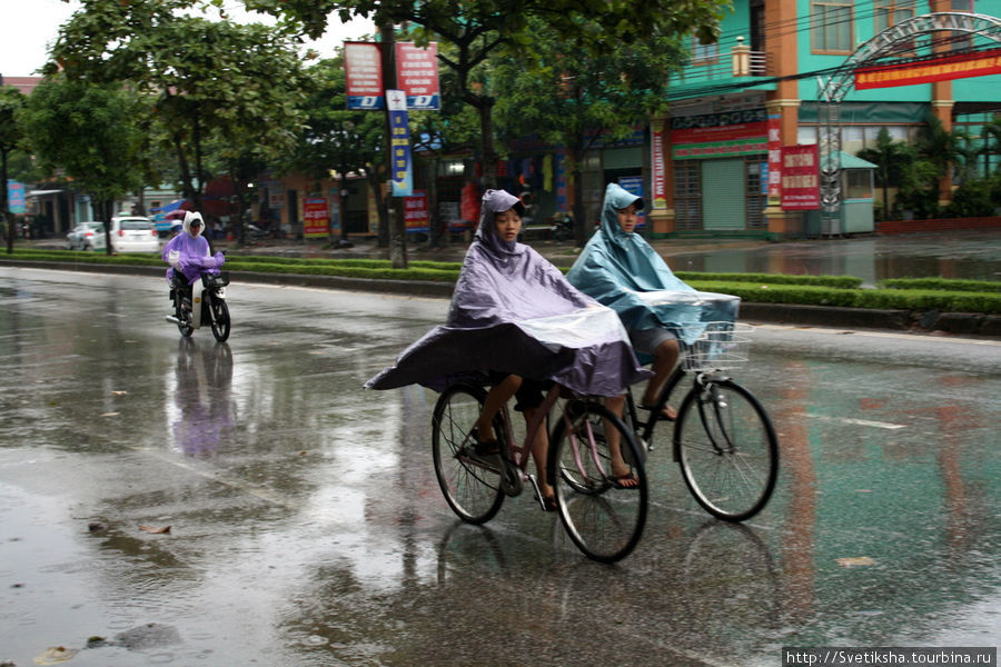 На велосипеде под дождем можно только в дождевике или под зонтиком Винь, Вьетнам