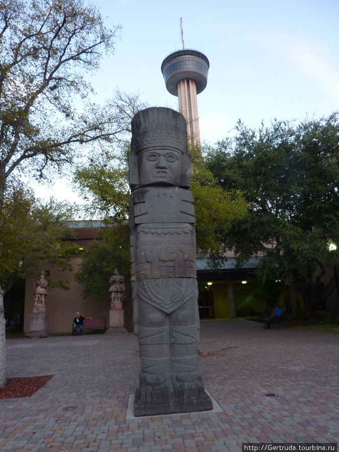 Каменный идол на фоне башни Сан-Антонио, CША