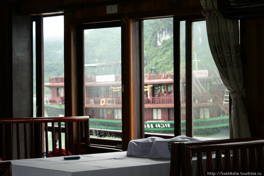 Вид из окна одного судна (помещения, где все обедают) на другое Халонг бухта, Вьетнам
