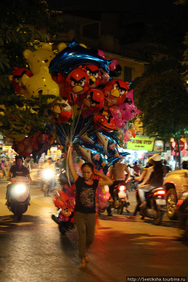 Продавщица воздушных шаров на ночном базаре в квартале ремесленников Ханой, Вьетнам