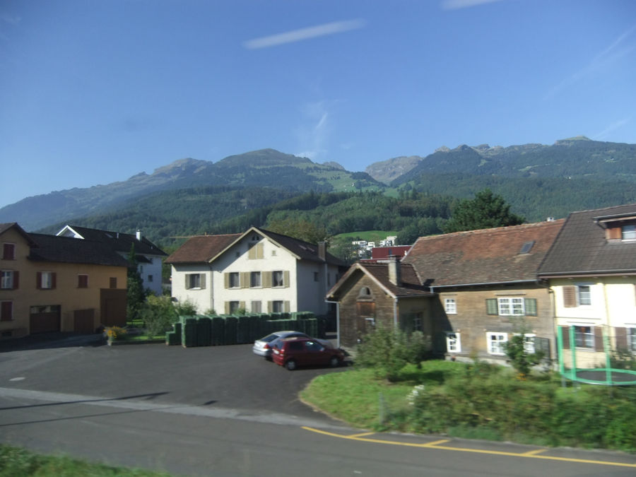 Справа Швейцария, слева Лихтенштейн. Это небольшое государство проезжаем практически по всей длине его западной границы. На стоянке возле магазина машины с чёрными лихтенштейнскими номерами. Когда-то в СССР тоже были чёрные номера. Лихтенштейн