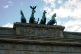 Над воротами возвышается знаменитая и часто фотографируемая Квадрига работы Готфрида Шадова, построенная в 1793 г, на которой изображена статуя богини Мира Айрене, правящая колесницей, запряженной четырьмя конями