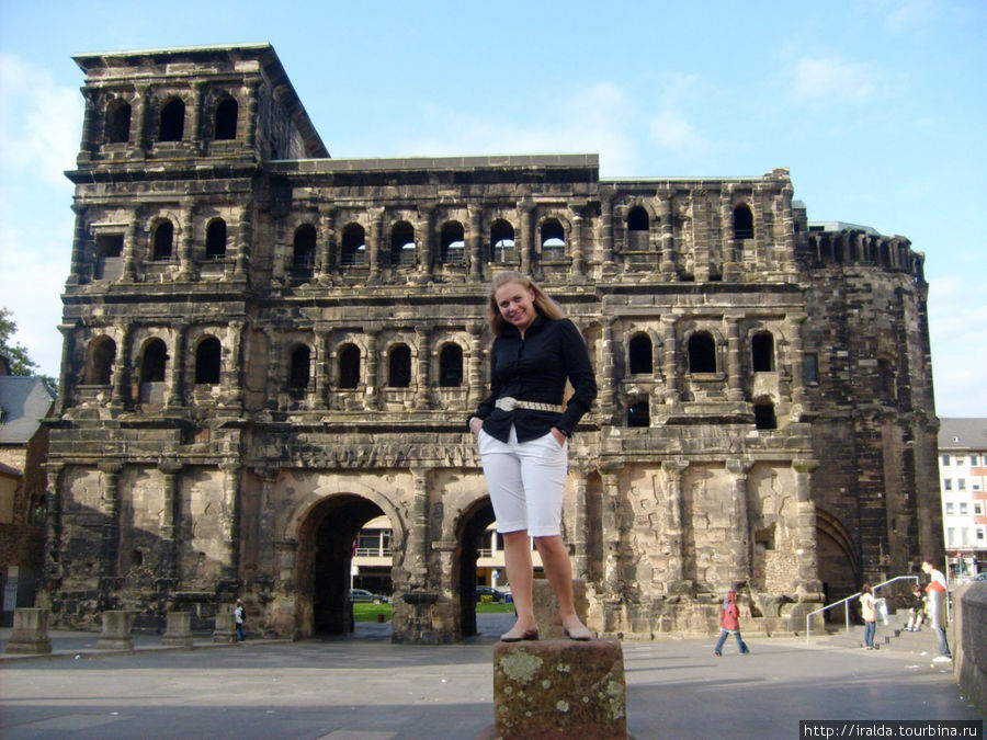 Легендарные Черные ворота (Porta Negra), чьи некогда светлые камни потемнели от ветров и непогоды, высятся как последнее из четырех укреплений защитного кольца города Трир, Германия