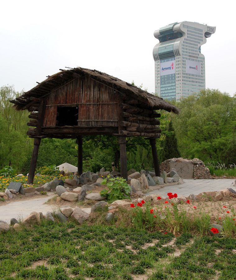 На переднем плане сооружение в парке, а на заднем за его пределами. Пекин, Китай
