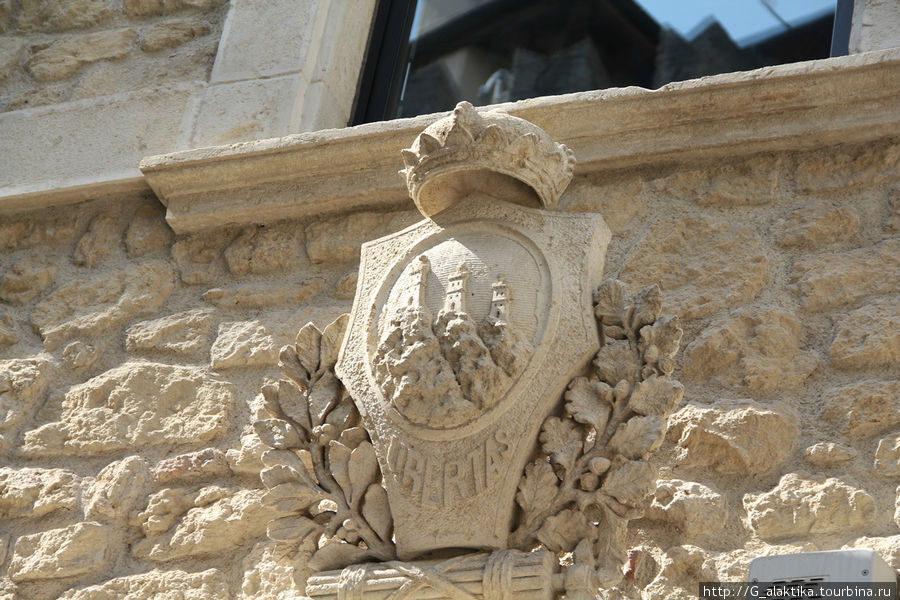 Герб Сан-Марино имитирующий трехглавую  гору Титано, с замками. Сан-Марино