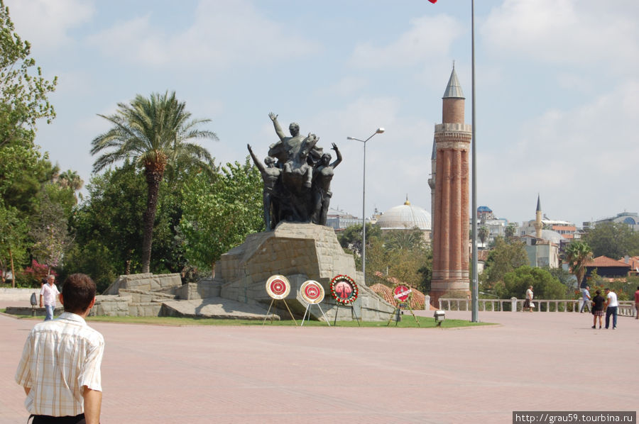 Минарет справа,  слева памятник Ататюрку Анталия, Турция