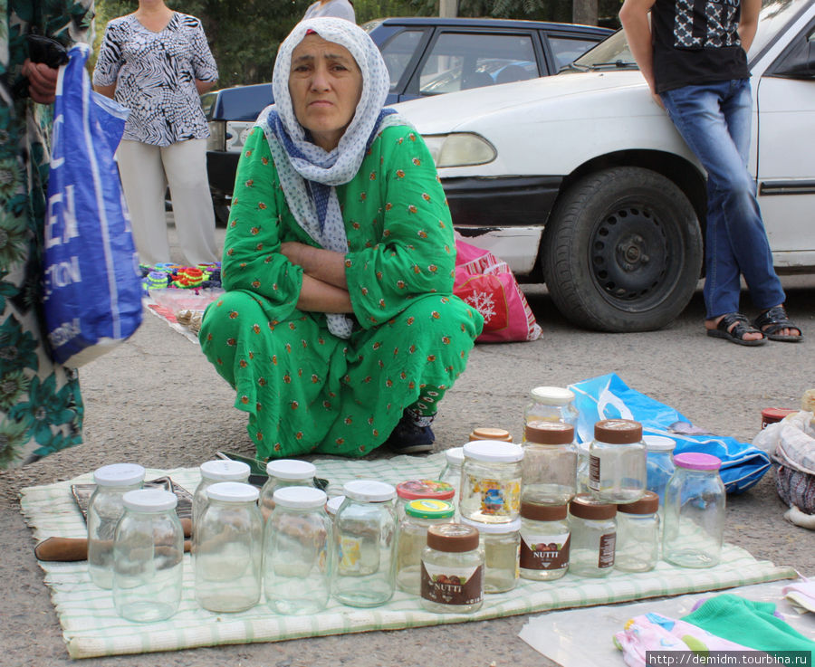 Грустная таджикская тетушка продает пустые банки.