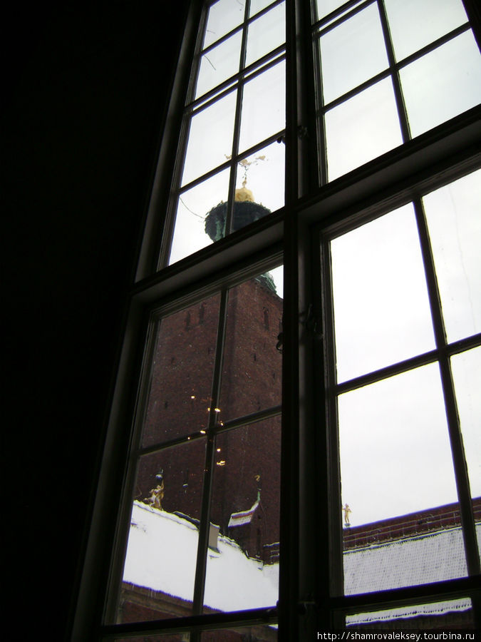 в окна виден большой двор Ратуши и башня с тремя коронами на шпиле. Стокгольм, Швеция