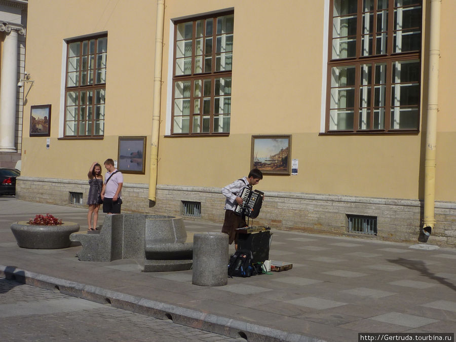 Картины на стене здания и очередной музыкант. Санкт-Петербург, Россия
