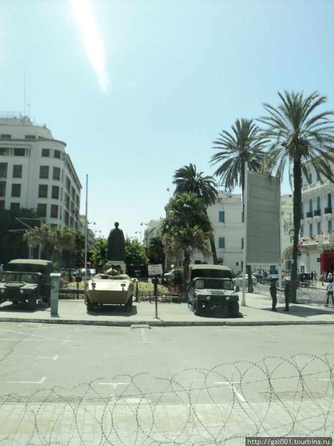 На центральном проспекте Туниса: колючая проволока, бронетранспортеры, полицейские машины на фоне безмятежной столичной жизни. Тунис