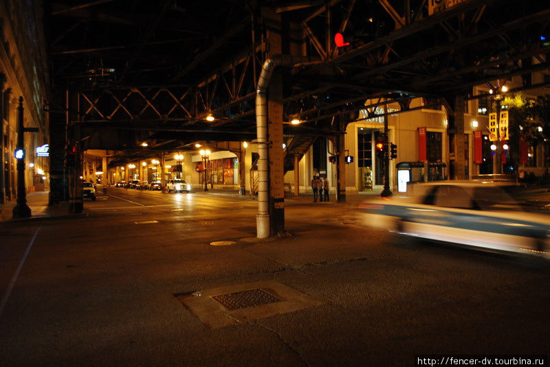 Метро в даунтауне проходит местами над землей, что придает вечернему городу особую мрачность Чикаго, CША