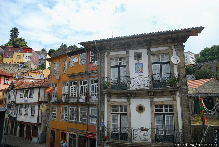 На балконе часто висит азулейжос со святым. Азулейжос — традиционный португальский изразец. Порту, Португалия