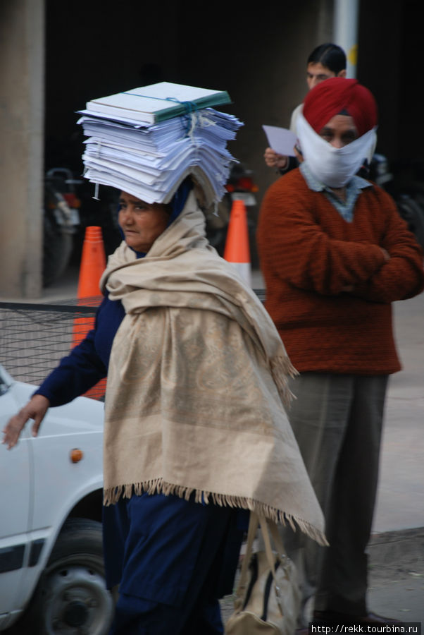 Во всей Индии на голове носят кувшины или узлы. В треугольнике, образованном зданиями трех ветвей власти женщины носят, конечно же, бумаги. Торжество бюрократии!!! Чандигарх, Индия