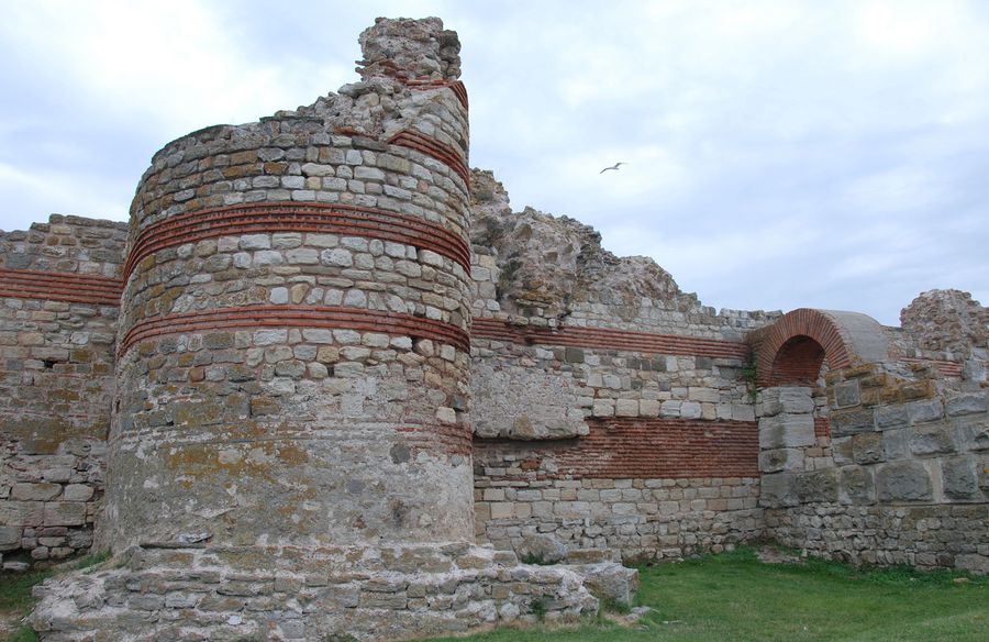 Западная крепостная стена Несебра являлась частью укрепительной системы города. В настоящее время большая часть системы находится под водой. Длина сохранившегося участка стены достигает 100 м, а максимальная высота 8 м. Построена смешанной кладкой = опус микстум. Ранневизантийская стена (V—VI в.) следует трассе фракийской (VIII—VI в. до н. э.) и античной (IV—III в. до н. э.) крепостной стены. Северный и южный края стены находились в море, играя роль стен причалов для двух городских пристаней. Ворота, расположенные напротив перешейка, огорожены двумя пятиугольными башнями. В стороне от них были симметрично построены полукруглые и круглые башни. Две двери- опускающаяся и двухстворчатая — плотно закрывали основной вход в город. Документированы пять реконструкций стены в период с VII по XIX в. Основные раскопки и изучение сохранившихся частей крепостной стены велись с 1958 до 1969 г., после чего с 1970 до 1981 конcервировались и реставрировались. Несебр, Болгария