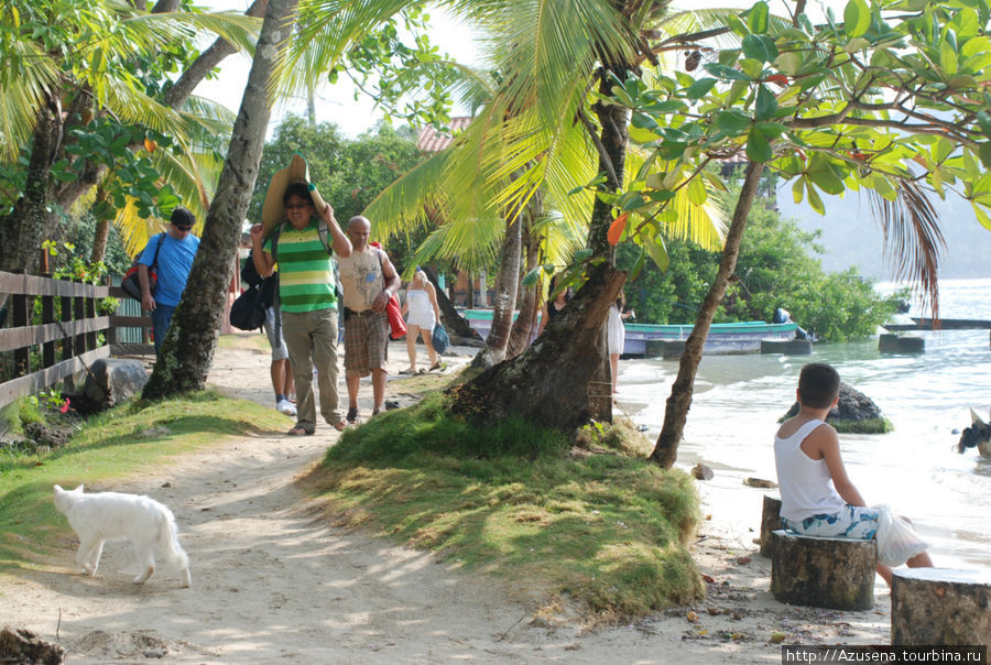 Отдыхающие выдвигаются на большой общественный пляж. Остров Исла Гранде, Панама
