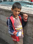 Мальчик-курд пытается продать салфетки иностранцам.