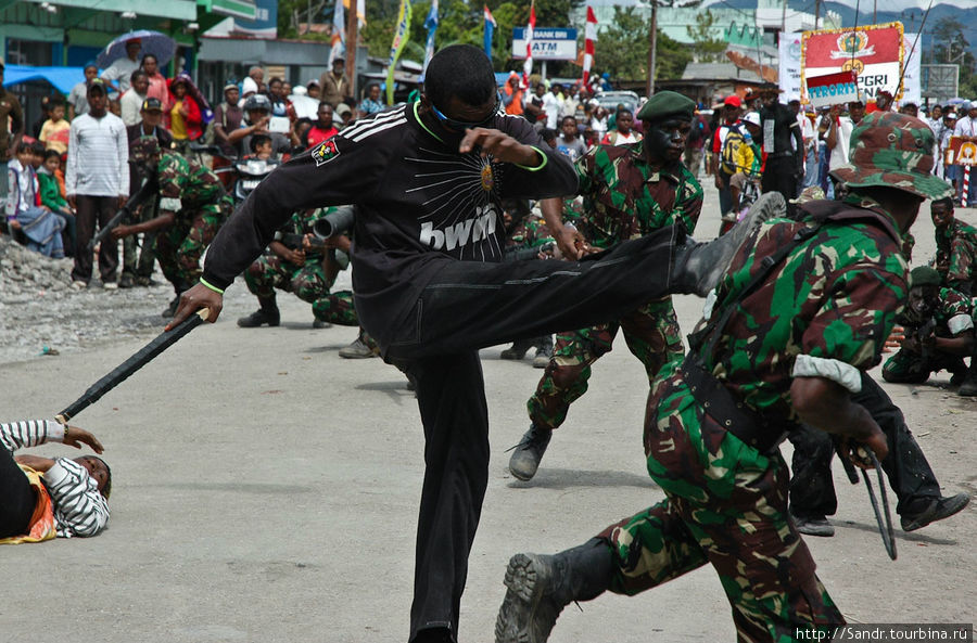 Студенты разыгрывают драку между солдатами и террористами. Вамена, Индонезия