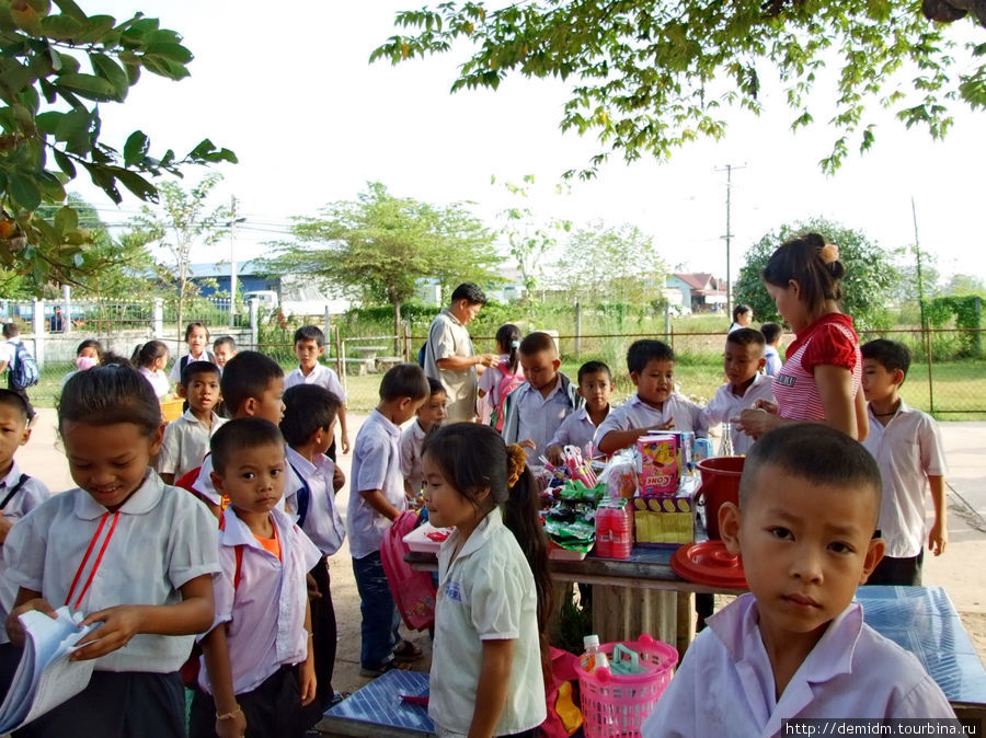 Занятия закончились. Дети ждут родителей, играют. И тут же под деревом маленький лоток со сладостями. Вьентьян, Лаос