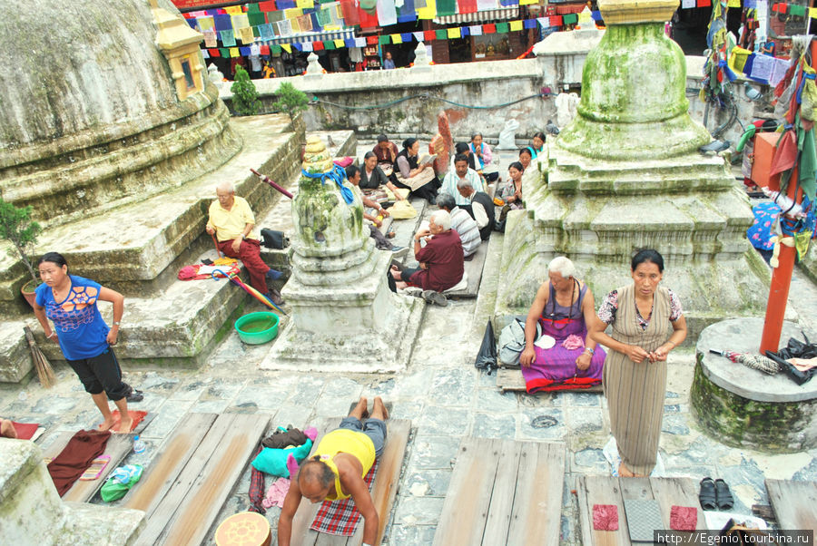 тибетцы, выполняющие перед ступой простирания, одну из медитативных практик Катманду, Непал