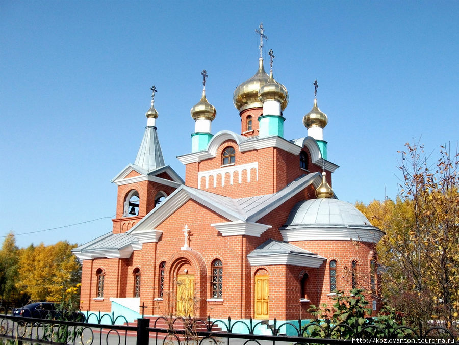За стадионом — Богоявленская церковь, открытая в 1998 г. Бачатский, Россия