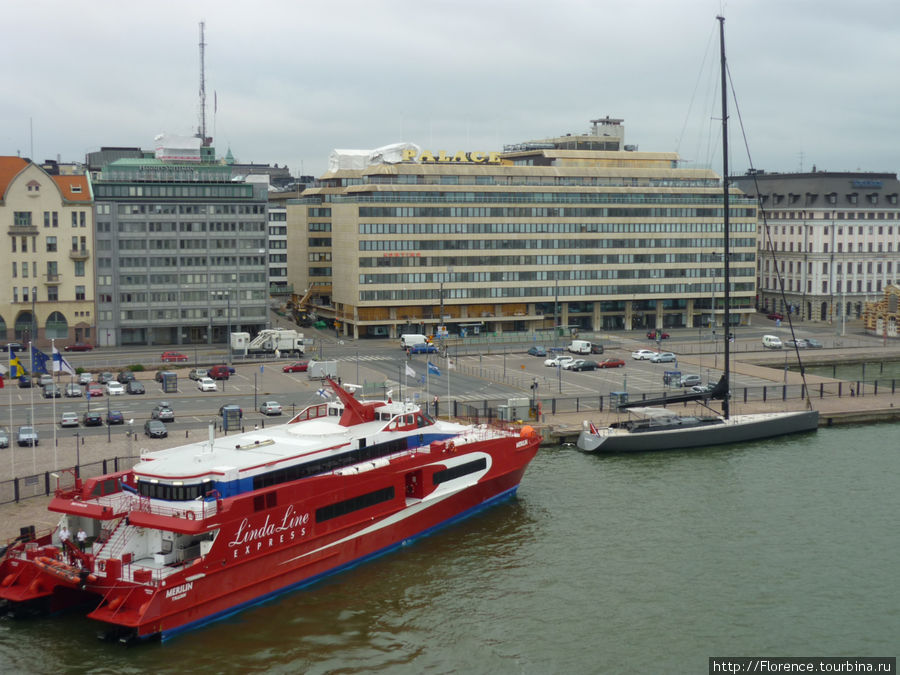 В порту стоит скоростное судно, а также огромная яхта, по-видимому только что построенная и еще недооборудованная Финляндия