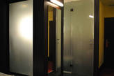Светящееся матовое стекло слева — это задняя стенка душа, который находится в центре комнаты.