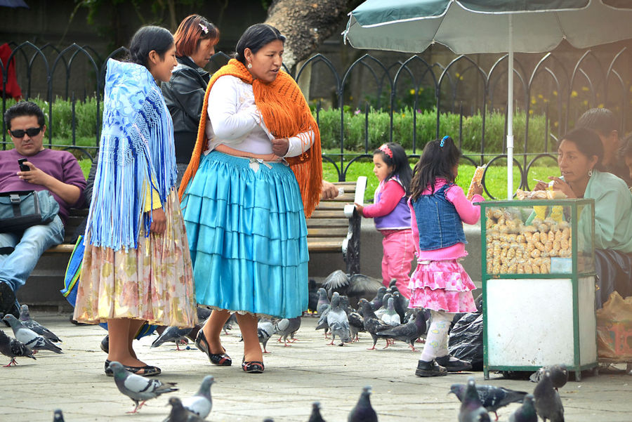 Дело в том, что значительную часть населения Боливии составляют местные индейцы — в основном, аймара и кечуа. Те из них, кто в совершенстве выучил испанский язык и осел в городе, называются «чоло». Надо сказать, несмотря на свою испаноязычность и городскую (даже столичную!) прописку — они нисколько не изменяют своим корням, образу жизни и нарядам. Первое, что обязательно должна иметь любая уважающая себя боливийская модница — это пышная роскошная юбка со множеством ярусов и оборочек. Если материал попадется сверкающий и переливающийся — вообще отлично! ;) Ла-Пас, Боливия
