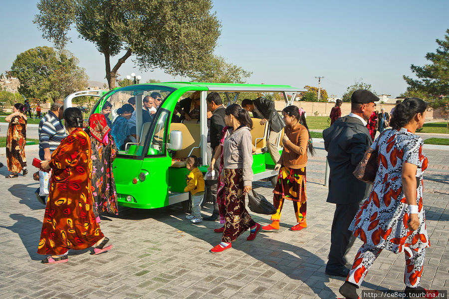 Народ садится и выходит из специальной электромаршрутки, которая курсирует между рынком и главной улицей по пешеходной аллее Самарканд, Узбекистан