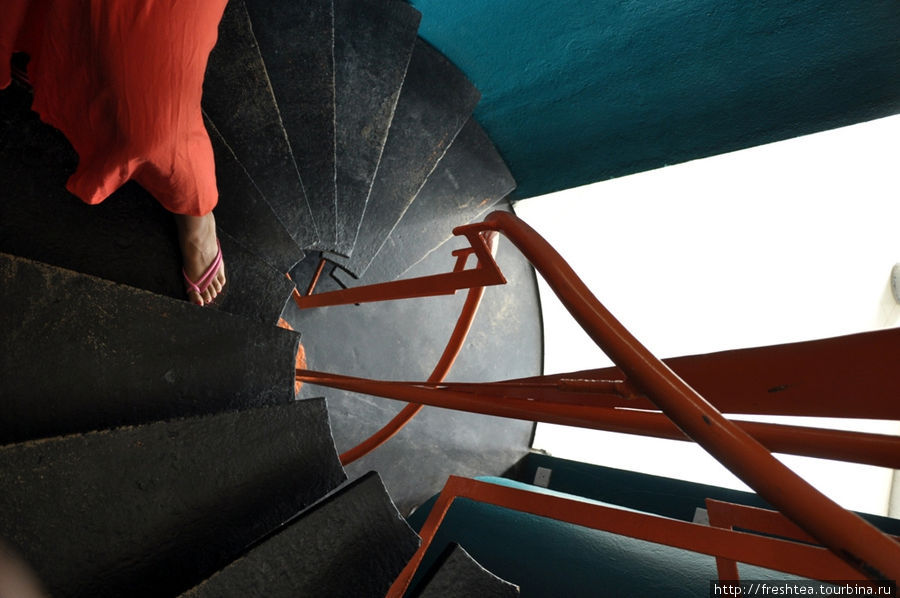 Переходы между ярусами — через яркие, аквамаринового оттенка барабаны, внутри которых завинчена в спираль черная лестница в обрамлении оранжевых поручней. Тангалла, Шри-Ланка