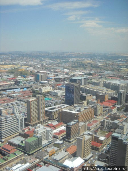 Особенно хорошо заметно, как город начинается высотками, потом переходит на здания поменьше, а к горизонту застройка снисходит на одноэтажки Йоханнесбург, ЮАР