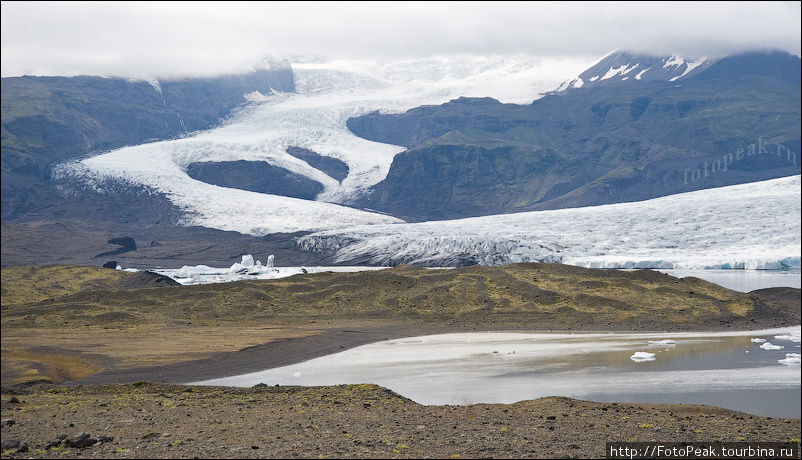 Когда рассеивается облачность, становится видно, что ледник на самом деле просто огромный. Южная Исландия, Исландия