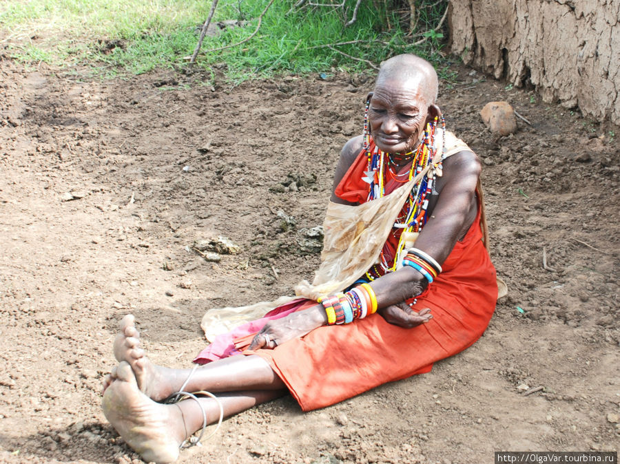 Даже в преклонном возрасте женщины-масайки украшают себя, не прекращая носить  бесчисленные браслеты, металлические и из слоновой кости, на руках и щиколотках. Этой пожилой масайке, как нам сказали, 80 лет. Сама она не проронила ни слова... Масаи-Мара Национальный Парк, Кения