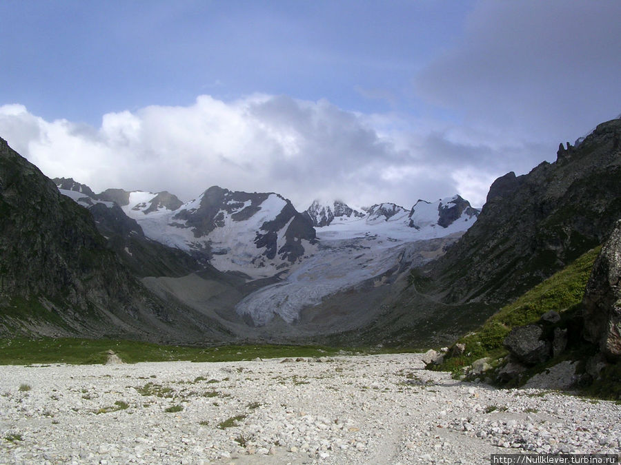 Вид на зеленую гостиницу по возвращении назад... 
Из видимых гор самой простой для альпинистов здесь считается Трапеция, она по центру, также видно как свисает один из ледников. Кабардино-Балкария, Россия