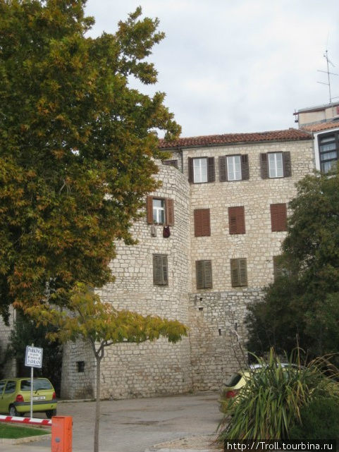 Классическая местная постройка на набережной, вобравшая фрагмент стены Шибеник, Хорватия