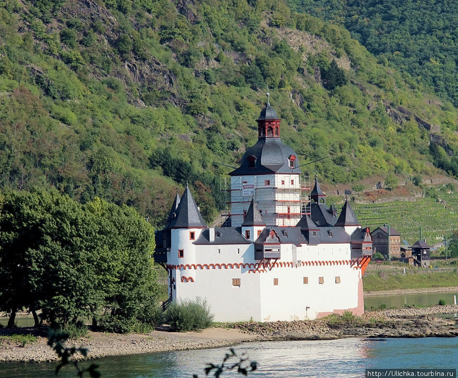 Замок Пфальцграфенштайн (Burg Pfalzgrafenstein) на 546 километре течения Рейна считается одним из самых необычных и живописных замков не только в Германии, но и в Европе. Французский писатель Виктор Гюго назвал его каменным кораблем, навечно вставшим на якорь посреди реки. Сравнение напрашивается само собой, но строители и хозяева замка в XIV веке вряд ли думали об эстетической стороне дела или о впечатлении, которое он произведет через много столетий на писателей эпохи романтизма или на туристов XXI века.Первой целевой группой, на которую замок должен был произвести впечатление, были владельцы и капитаны торговых кораблей. В этом месте они расставались с частью своих звонких монет — платили таможенный налог. Требования при необходимости подкреплялись пушечной пальбой. Веским аргументом для особо строптивых купцов была массивная цепь, своего рода шлагбаум, которую поднимали со дна, преграждая дальнейший путь. Земля Рейнланд-Пфальц, Германия