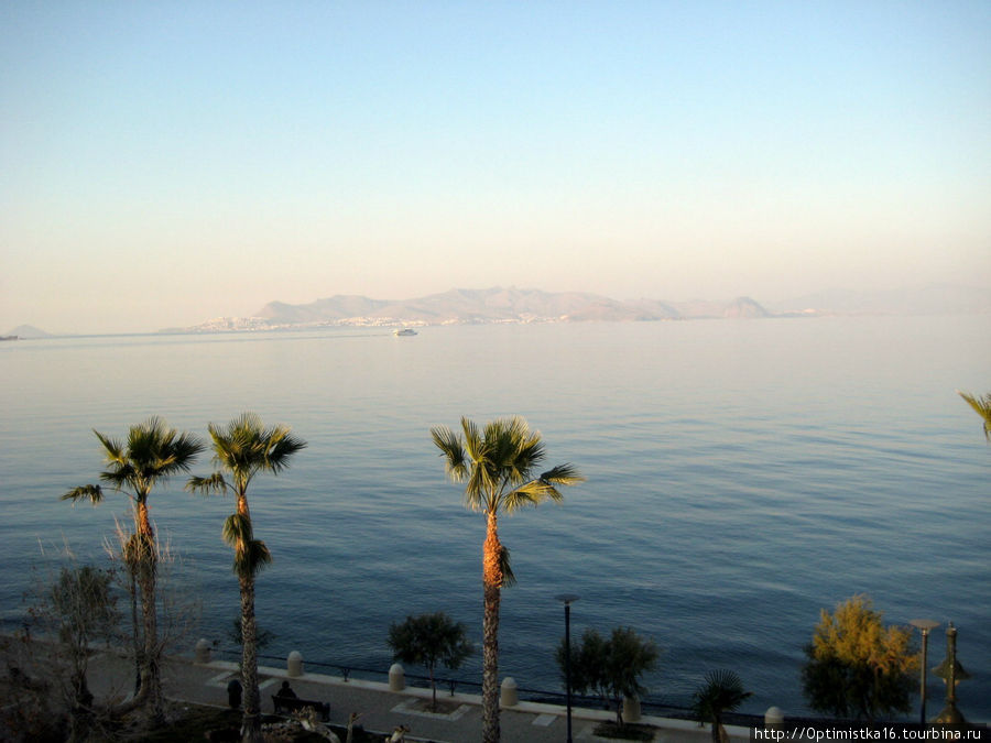 Море, горы, замок, корабли и одинокий пловец в декабре Кос, остров Кос, Греция