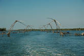 Так называемые китайские рыболовные сети представляют собой блочный подъемный механизм. Управляются они командой из 3-4 человек, которая погружает в воду и поднимает оттуда сеть, натянутую на эти торчащие 4 пальца. Только, как можно разглядеть, сетей-то нету, стоят одни остовы. Думаю, сети сняли из-за запрета на рыбную ловлю этим методом.