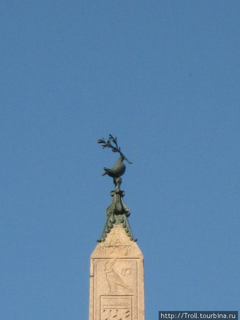 На высоте египетского обелиска птица с чем-то в клюве Рим, Италия