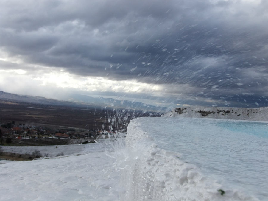 на вершине порывы ветра поднимают брызги падающей воды вверх Памуккале (Иерополь античный город), Турция