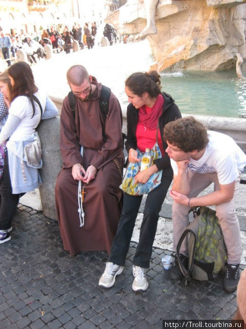Рядом с туристами сидит монах в рясе Рим, Италия