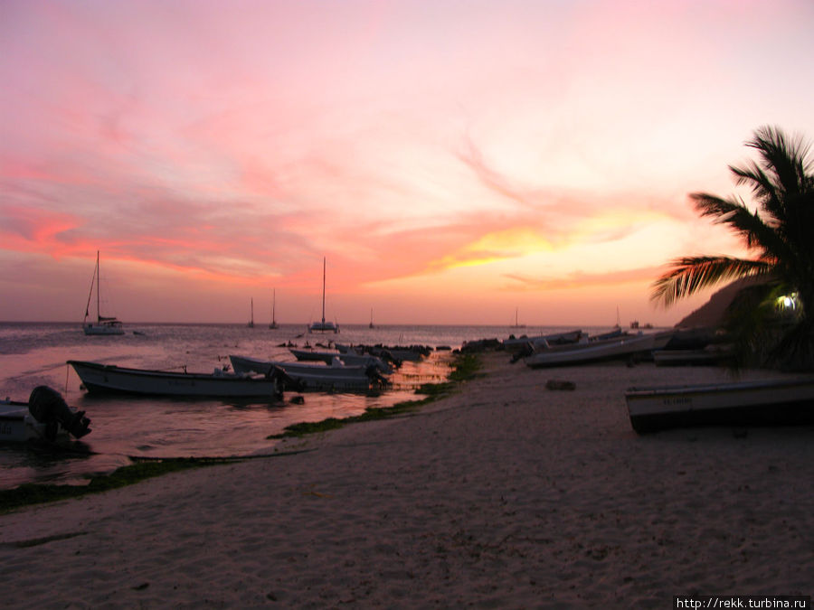Солнце садится и в тишине Вы бредете вдоль пляжа на звуки гитары около прибрежного бара Архипелаг Лос-Рокес, Венесуэла