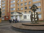 Памятник Сотворение мира и на заднем плане у него городской ЗАГС